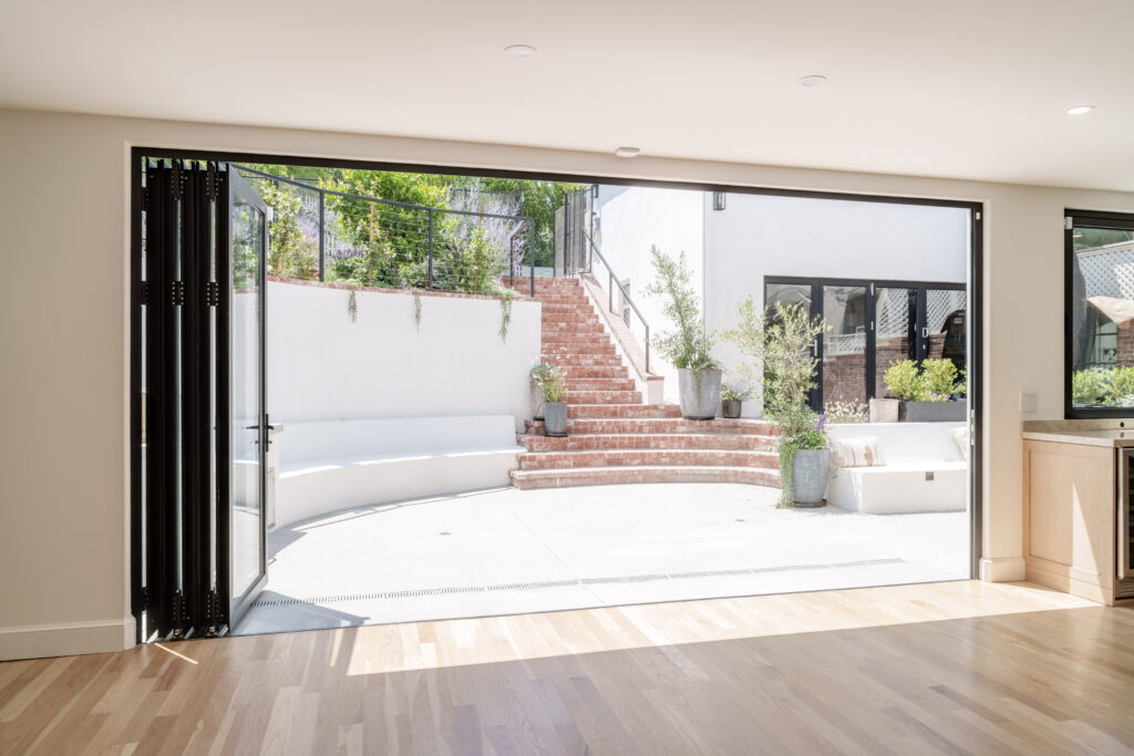 Large glass bifold doors fully opened to outdoor patio