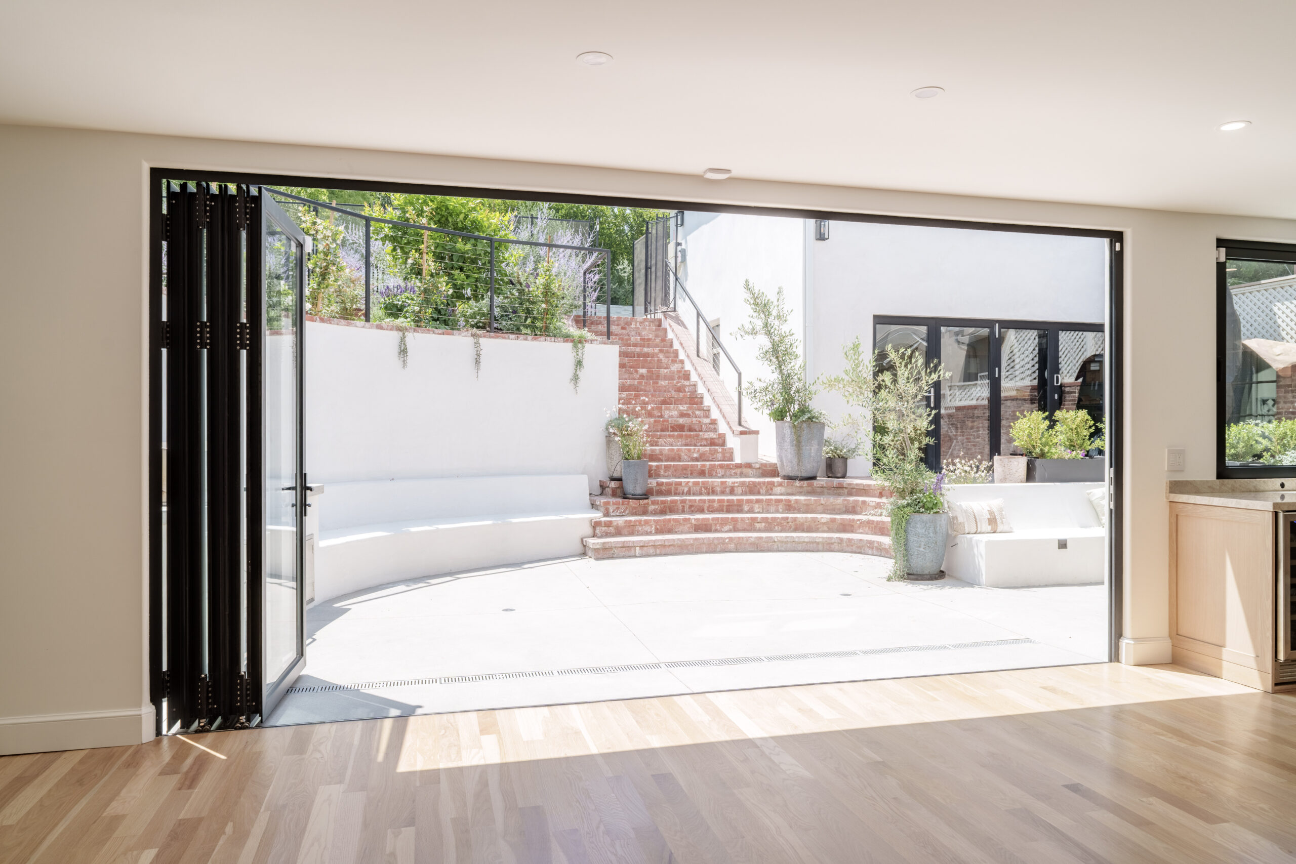 Large glass bifold doors fully opened to outdoor patio