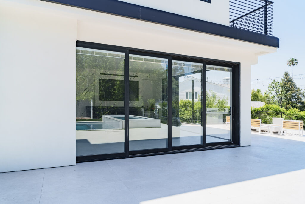Minimalist interior with glass-fold bifold doors and soft shadows